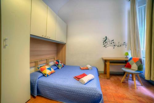 - une chambre avec un lit bleu et un bureau dans l'établissement Stilmoderno Nice Apartment in Siena's Historic Center, Just Steps from Piazza del Campo, à Sienne