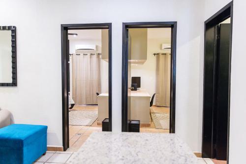 Una sala de estar con un taburete azul y un espejo. en Departamento familiar, en Playa del Carmen