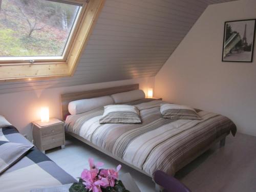 a bedroom with a bed with two lamps and a window at Chambres d'hôtes "Au Val Séjour" in Saint-Martin