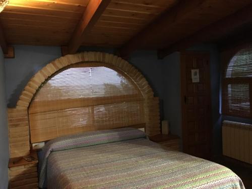1 cama en un dormitorio con una ventana abovedada en El Mirador, en Quinto
