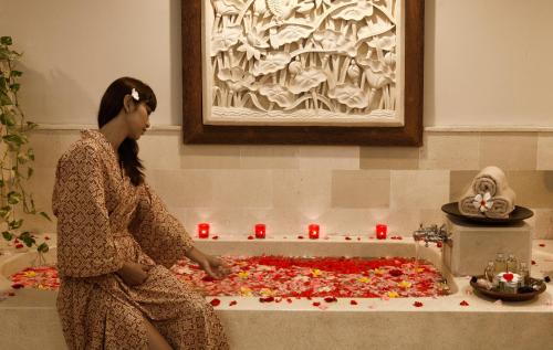 a woman is making a pizza with red candles at Bali Rani Hotel in Kuta