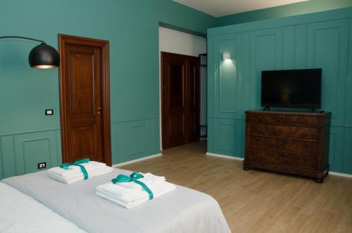 a bedroom with two towels on a bed with a television at Panoramica dei Templi B&B in Agrigento