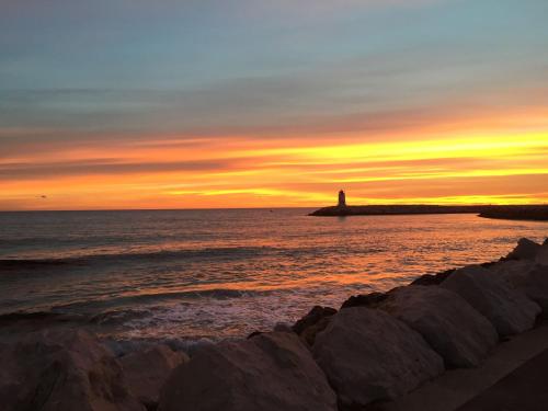 a lighthouse on an island in the ocean at sunset at L'ESCALE COTE BLEUE B&B AND Spa in Sausset-les-Pins