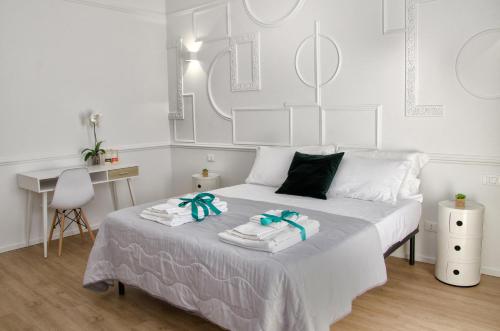 a white bedroom with a bed with towels on it at Panoramica dei Templi B&B in Agrigento