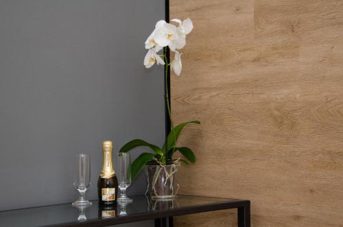 a vase of flowers on a table with a bottle of champagne at Panoramica dei Templi B&B in Agrigento