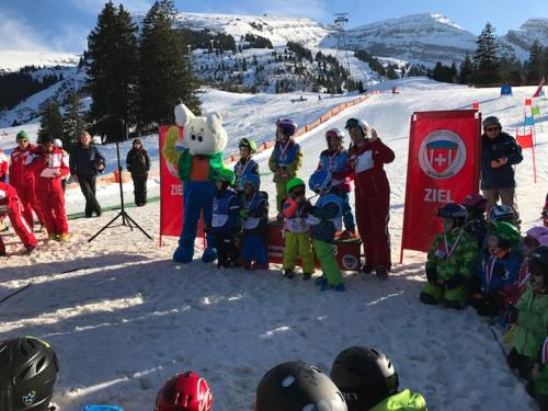 a group of children and a group of people in the snow at Jizerka in Unterwasser