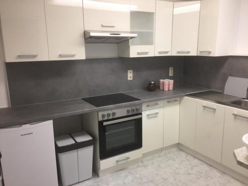 a kitchen with white cabinets and a stove top oven at Reikistudio Venedig in Quedlinburg