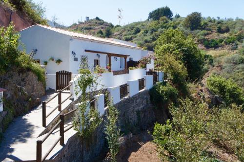 een huis aan de zijkant van een heuvel bij BELLA DORAMAS Casas Rurales Panchita & Millo in Moya