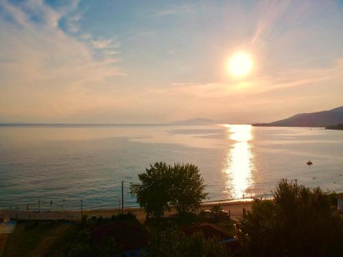 a sunset over a body of water with the sun in the sky at Pandora Studios in Kala Nera