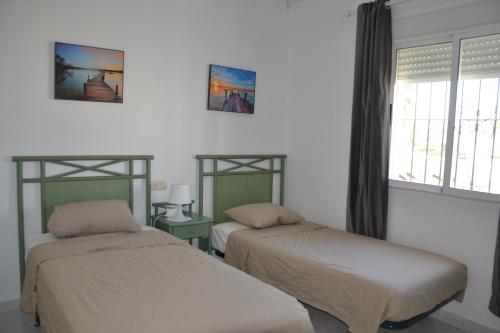 サン・ファン・デ・ロス・テレロスにあるCALLE PLUTON 77のベッドルーム1室(ベッド2台、窓付)
