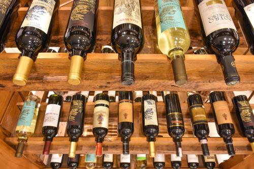 a bunch of wine bottles on wooden shelves at Rodoserv Hotel in Pardinho