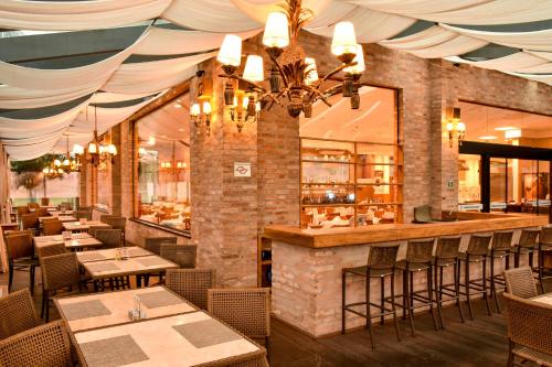 a restaurant with tables and chairs and a bar at Rodoserv Hotel in Pardinho