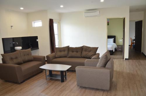 a living room with two couches and a table at Riverview Hotel in Bahau