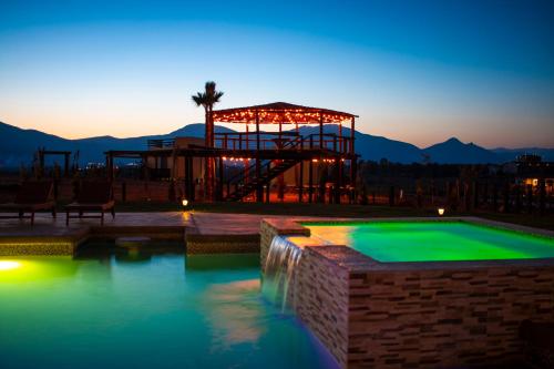 a large swimming pool with a playground in the evening at Cuatro Lunas Hotel Boutique in Valle de Guadalupe