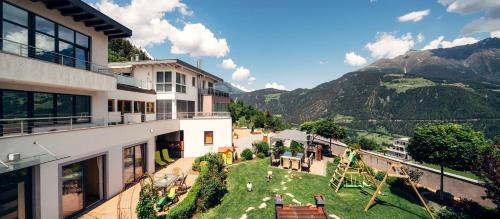 a balcony of a building with a yard with people at Apart Sunshine in Ladis