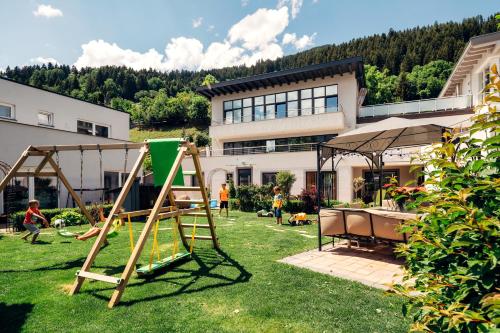 a playground in front of a house with people playing at Apart Sunshine in Ladis
