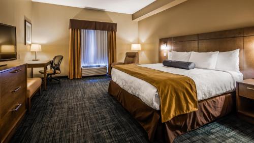 a hotel room with a large bed and a desk at Best Western Plus Winnipeg West in Winnipeg