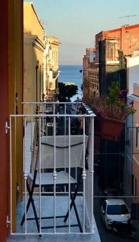 a chair sitting on the balcony of a building at Charming Rooms Opuntia in Carloforte