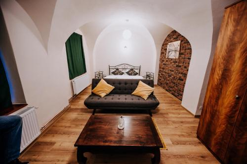 ein Wohnzimmer mit einem Sofa und einem Tisch in der Unterkunft Central am Brukenthal in Sibiu