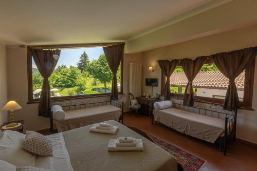 a hotel room with two beds and a large window at Agriturismo Nonna Du in Gavi