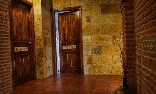 an empty room with two doors and a brick wall at Posada Puerta Grande in Candelario