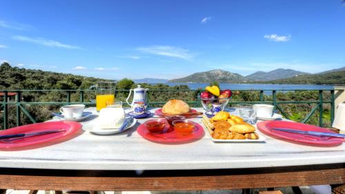 a table with food on it with a view of mountains at Gera's Olive Grove - Elaionas tis Geras in Perama