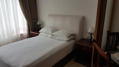 1 dormitorio con 1 cama con sábanas blancas y ventana en Suites Lerma 202, en Ciudad de México
