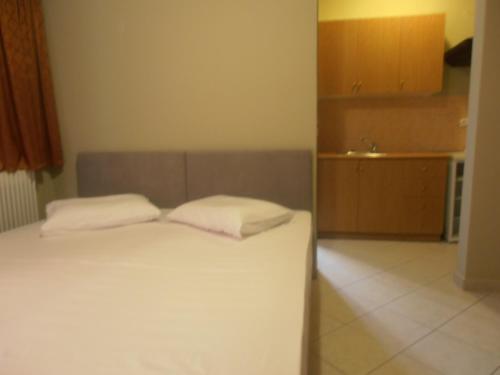 a bedroom with a bed with two white pillows at Melia in Aliveri