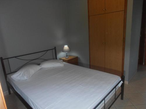 a bedroom with a bed and a dresser with a lamp at Melia in Aliveri