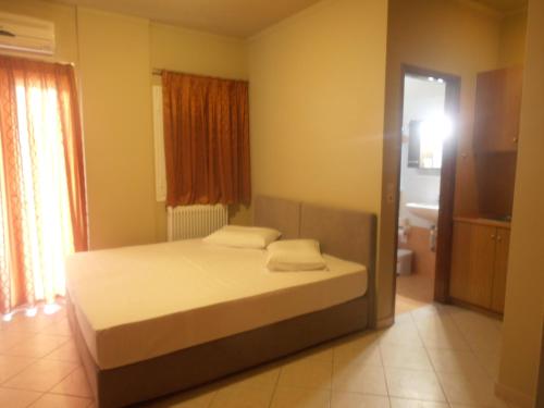 1 Schlafzimmer mit einem Bett und einem Bad in der Unterkunft Melia in Aliveri