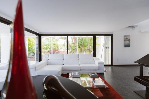 ein Wohnzimmer mit einer weißen Couch und einem Tisch in der Unterkunft Can Guasch in Sant Llorenç de Balàfia