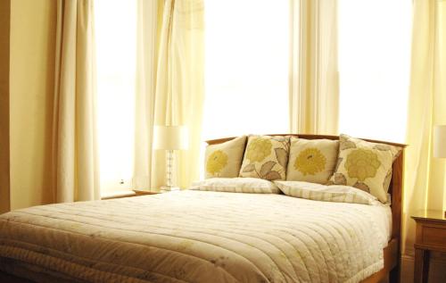 a bed in a room with a large window at Gordon House in Wimborne Minster