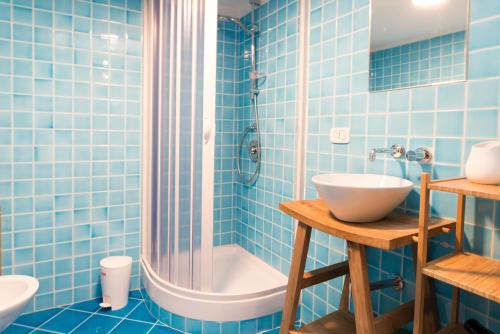 ナポリにあるBaraondab&bの青いタイル張りのバスルーム(シンク、シャワー付)
