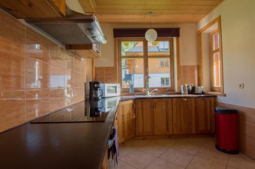 een keuken met een zwart aanrecht en een raam bij Sno House in Szczyrk
