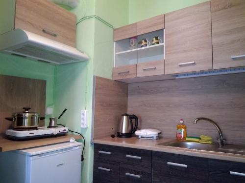 a kitchen with wooden cabinets and a sink and a stove at Rooms To Let Giannis in Makrýgialos