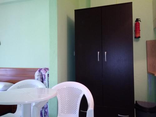 a white table and chairs next to a black cabinet at Rooms To Let Giannis in Makrýgialos