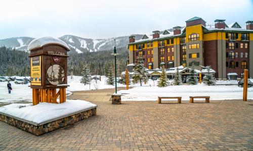 a clock in front of a building with snow on the ground at The Vintage Hotel in Winter Park