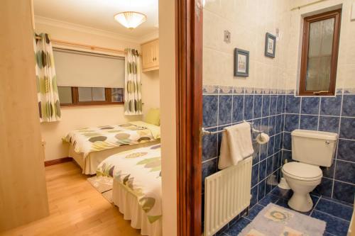 Rossgier Inn في Lifford: حمام بسريرين ومرحاض