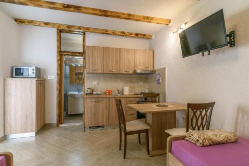 een kleine keuken met een tafel en een eetkamer bij Lorena in Trogir