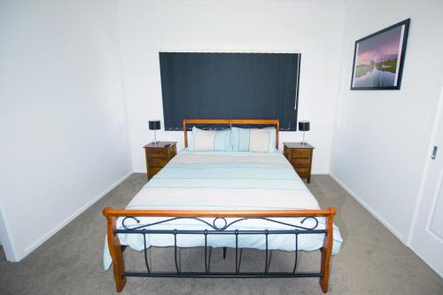 1 dormitorio con 1 cama y 2 mesitas de noche en Topaz Cottage en Glen Innes