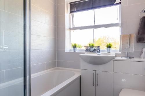 a bathroom with a tub and a sink and a bath tubermottermott at James Cook's Retreat in Middlesbrough