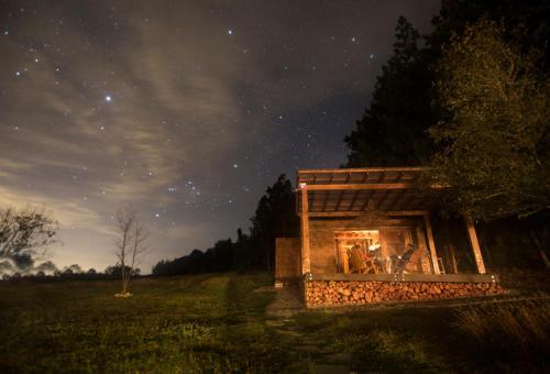 a building in the middle of a field at night at Niddo Suesca in Suesca