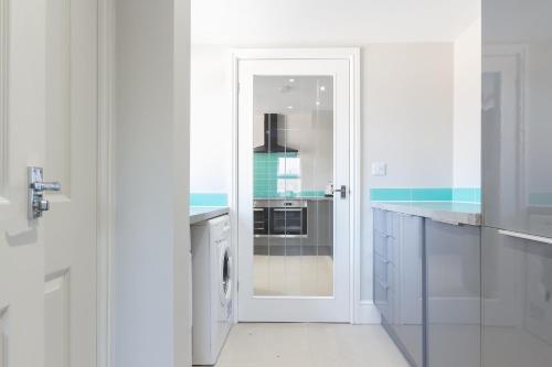 a white kitchen with a washer and dryer at James Cook's Retreat in Middlesbrough