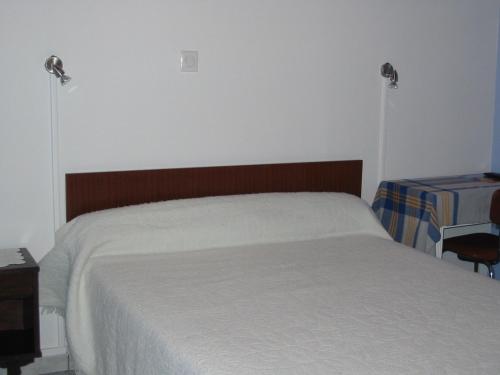 a bedroom with a bed with two lights on the wall at Auberge du Meygal in Champclause