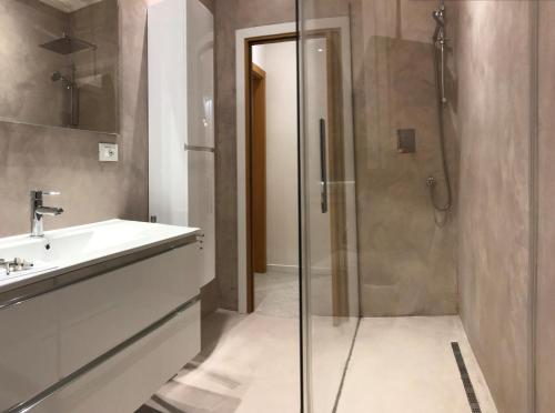 a bathroom with a glass shower and a sink at Suite i Gessi in San Ruffillo