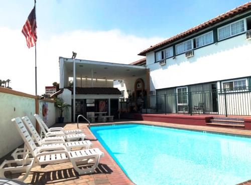 a swimming pool with lounge chairs next to a building at Americas Best Value Inn Loma Lodge in San Diego