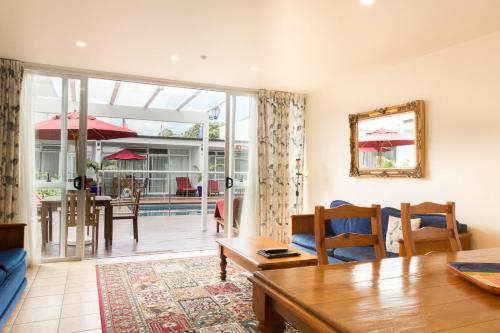 a living room with a table and a dining room at Commodores Lodge in Russell