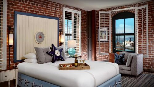 a bedroom with a large bed and a brick wall at Argonaut Hotel, a Noble House Hotel in San Francisco