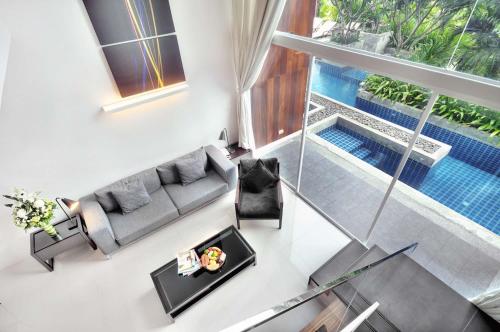 an overhead view of a living room with a couch and a pool at Mida De Sea Hua Hin - SHA PLUS in Cha Am