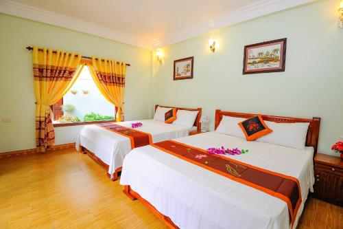 a bedroom with two beds and a window at Tam Coc Tuan Minh Homestay in Ninh Binh